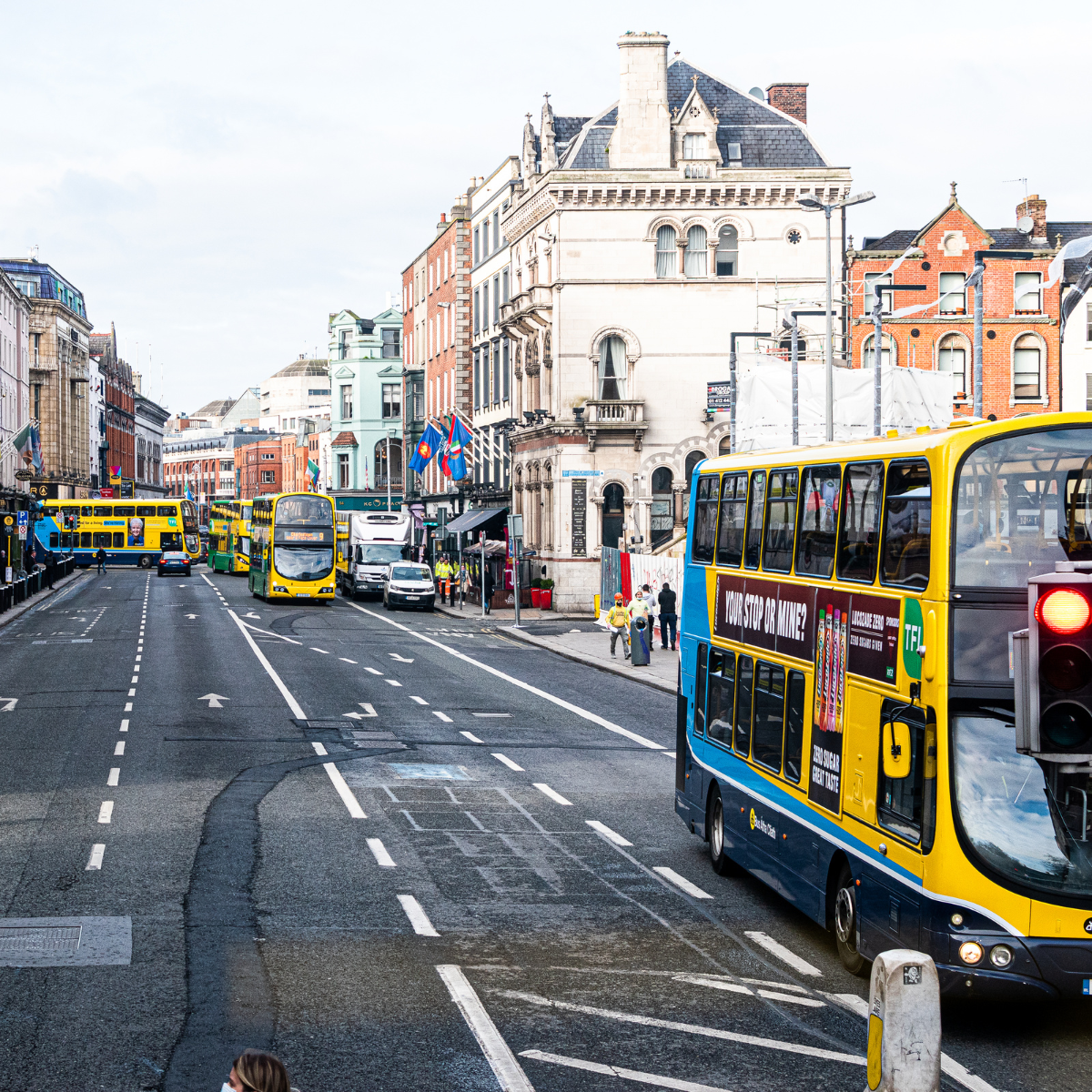 Rua movimentada em Dublin com ônibus e pessoas